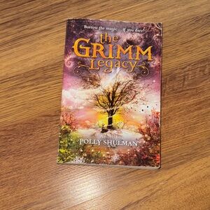 Scholastic The Grimm Legacy Book - Purple and Orange Cover